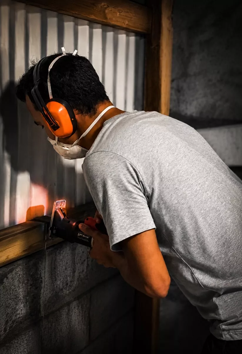 Thibaut Tintillier au travail sur un chantier, casque antibruit et masque de protection